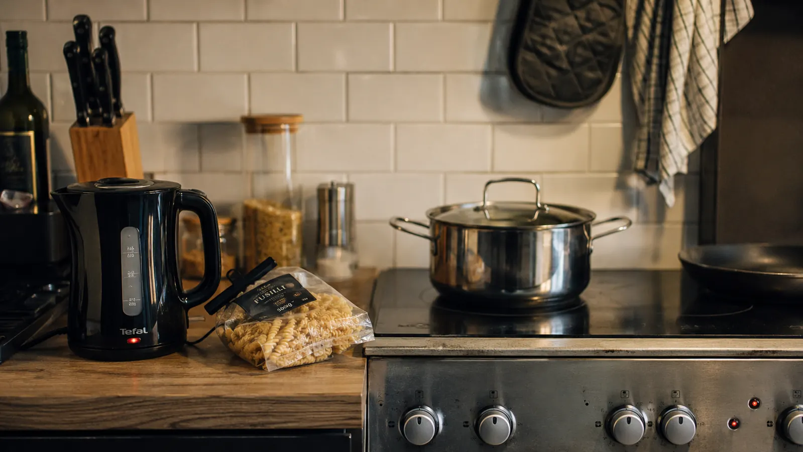 Small kitchen countertop showing an electric kettle beside pasta ingredients, showing how the kettle pre-boils water before it hits the pot